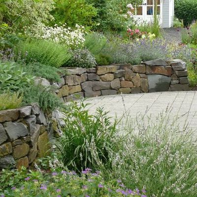 Die Bepflanzung mit mediterranen Kräutern über der Trockenmauer um die Terrasse erleichtert das Ernten auch bei Regen. Zudem ist es eine Freude, auf der erwärmten Trockenmauer zu sitzen und vom Duft der Kräuter in Urlaubserinnerungen entführen zu werden.